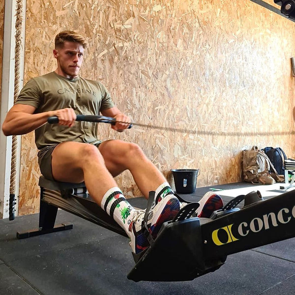 man on rowing machine in spooky gym socks halloween crossfit socks by HEXXEE